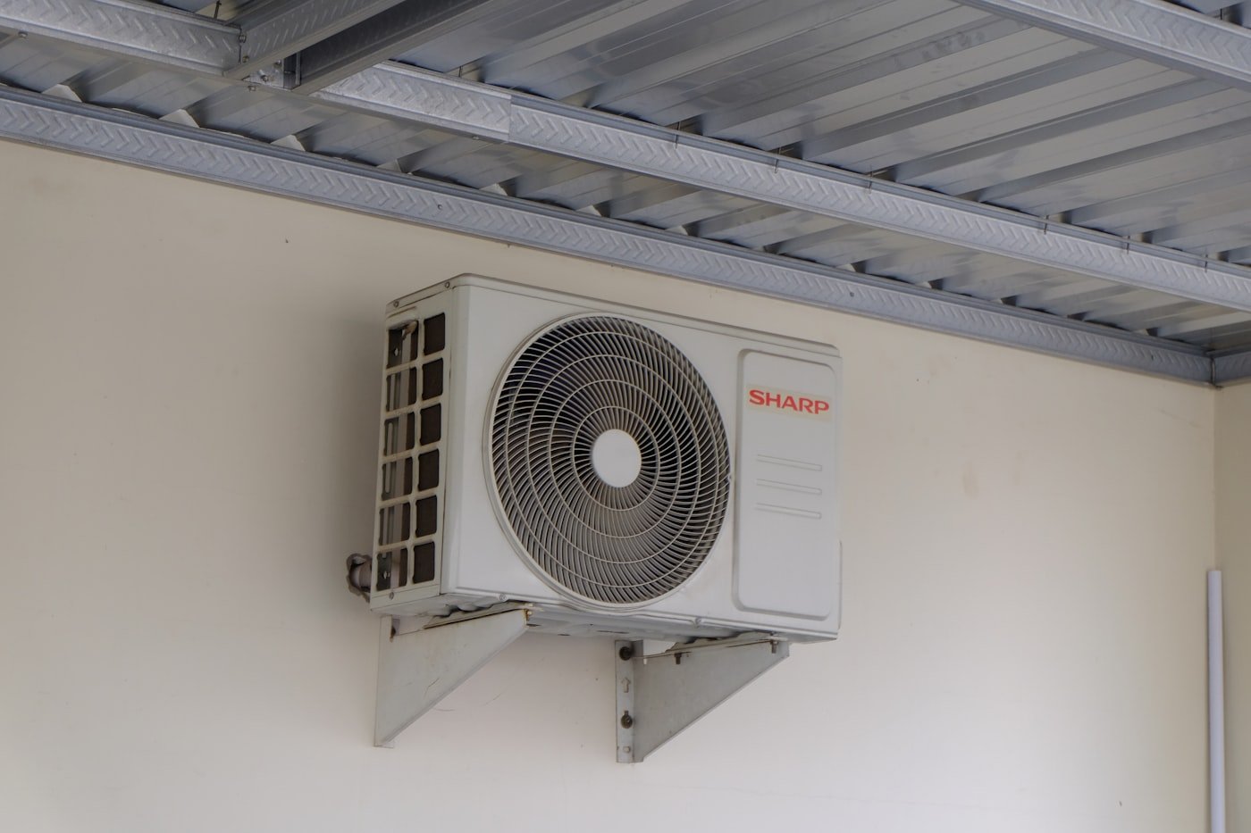 Unidad split inverter de aire acondicionado montada sobre pared exterior de una vivienda