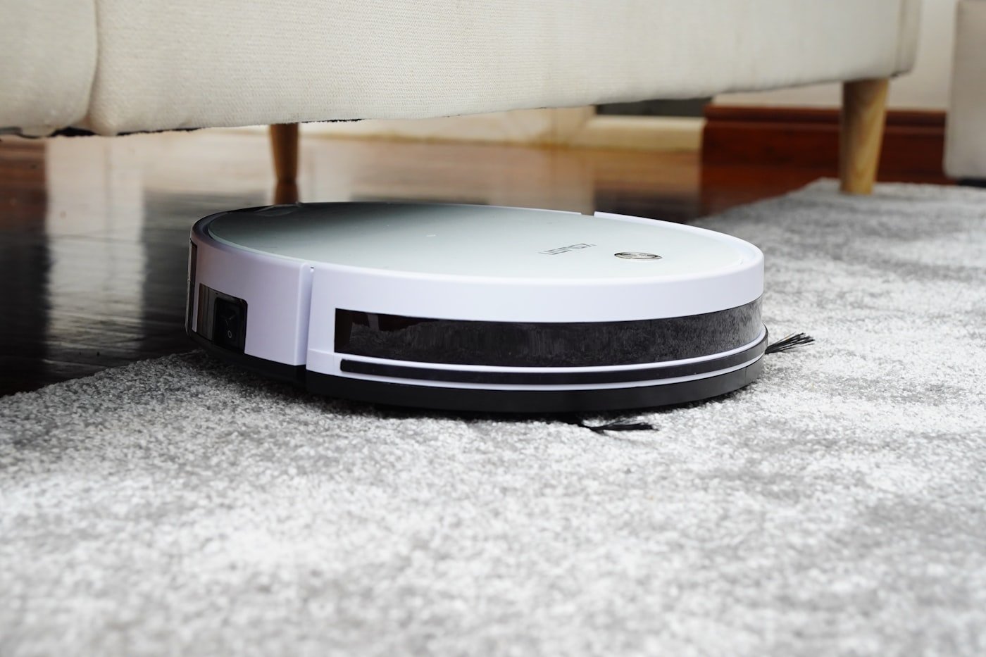 Aspiradora robot circular limpiando el piso de una casa