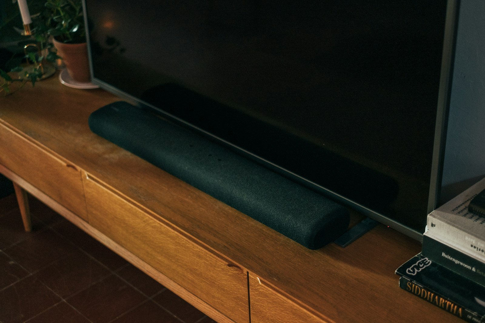 Living moderno con televisor y barra de sonido integrados en la decoración