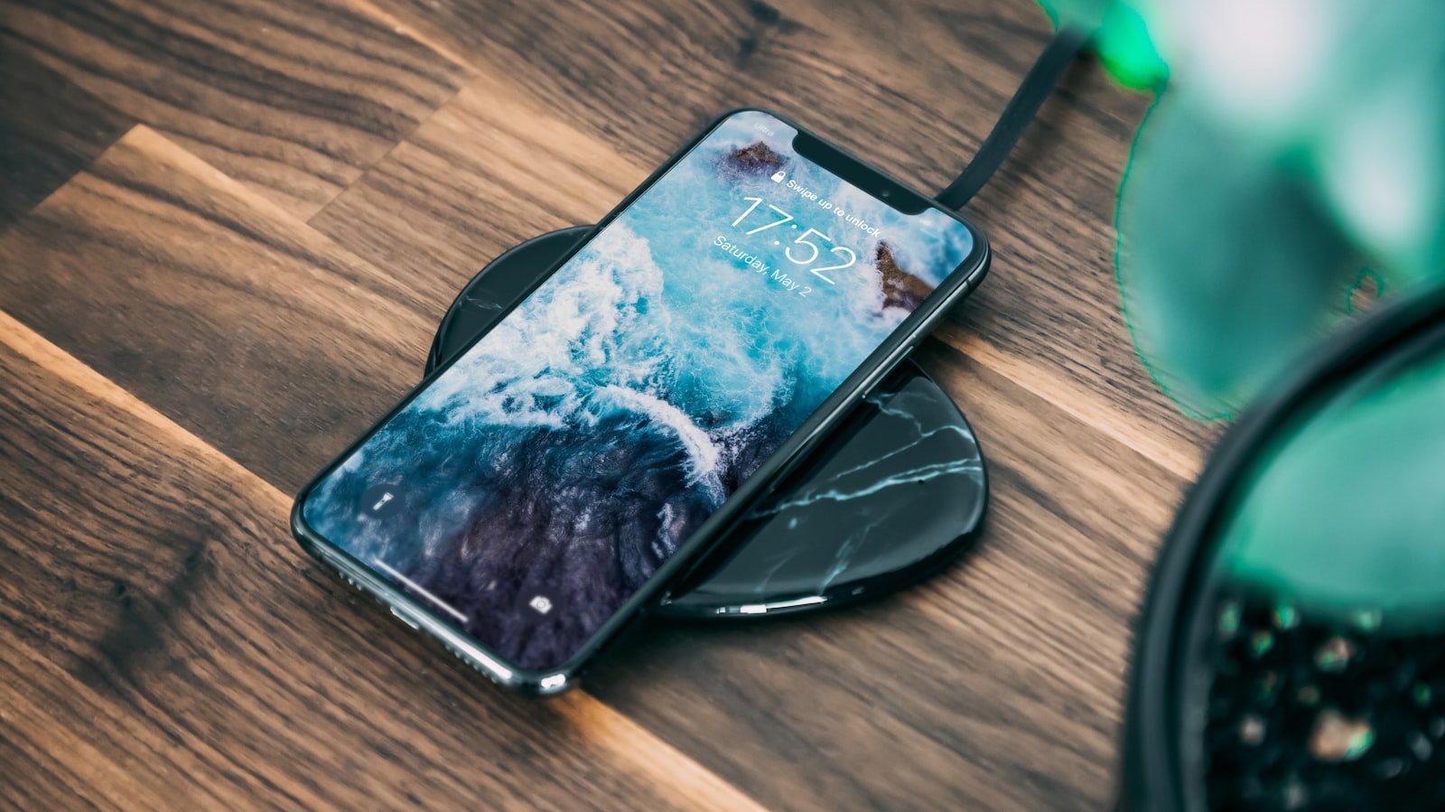Celular conectado a cable de carga rápida sobre superficie oscura