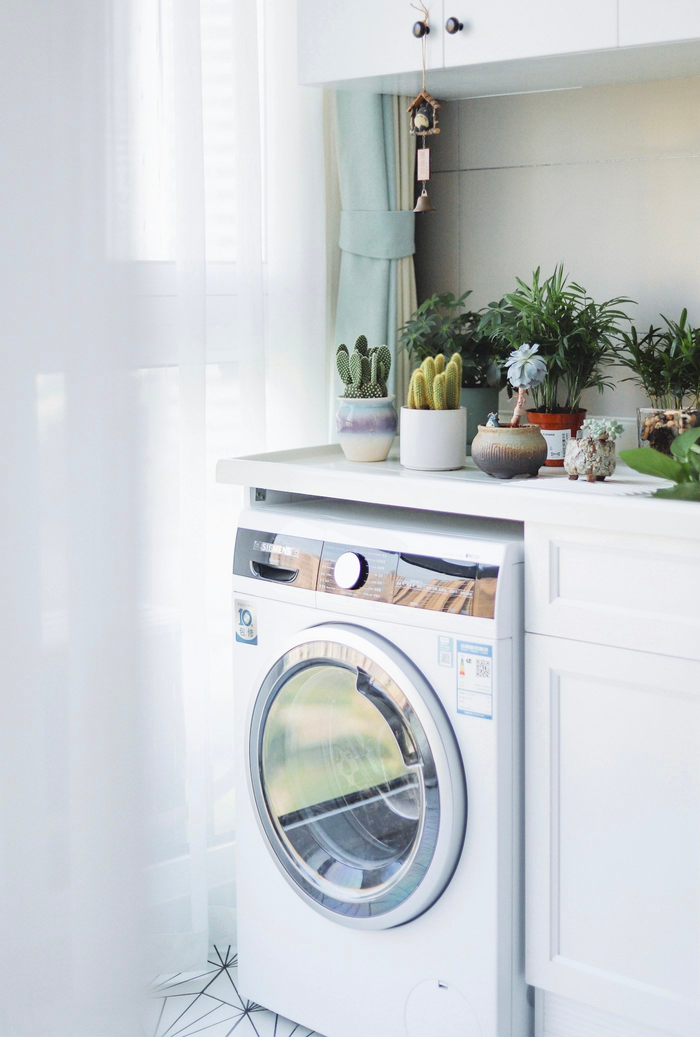 Lavarropas de carga frontal color blanco instalado junto a un mueble de madera