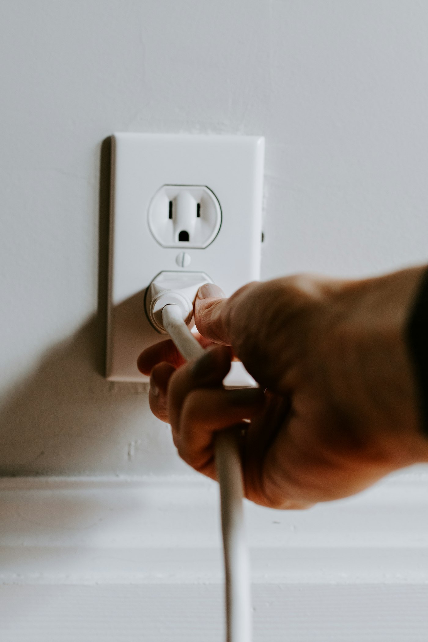 Persona conectando un dispositivo repelente eléctrico a un tomacorriente de pared