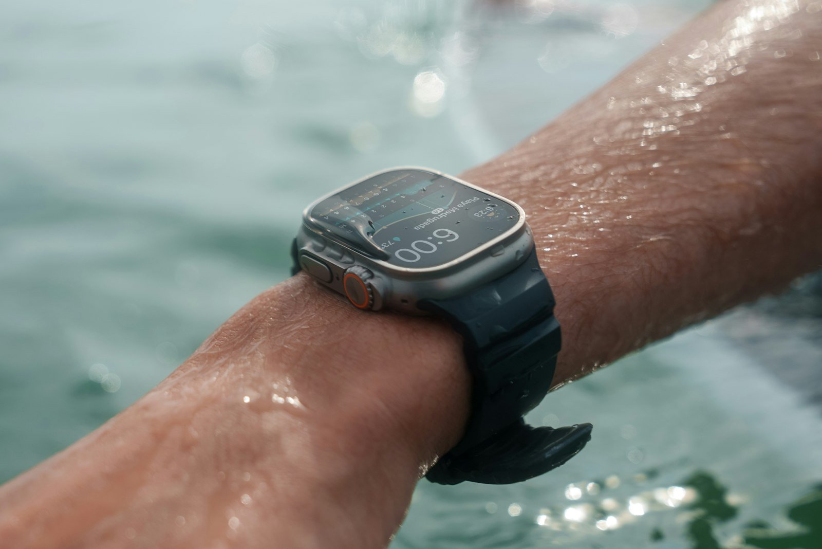 Persona nadando bajo el agua usando un smartwatch resistente al agua